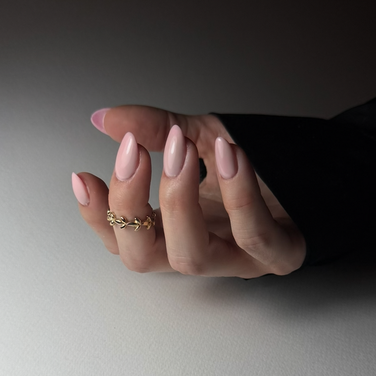 Hand with a gold ring on a neutral background